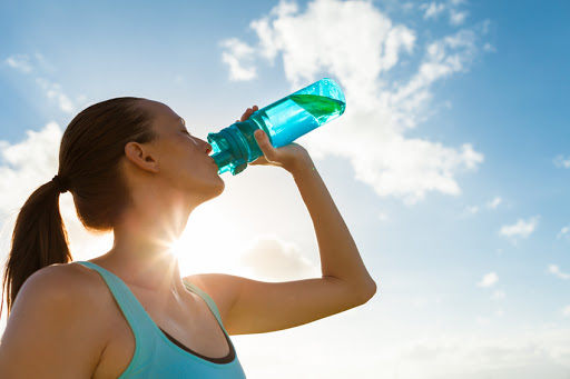Female drinking a fresh water from bottle.